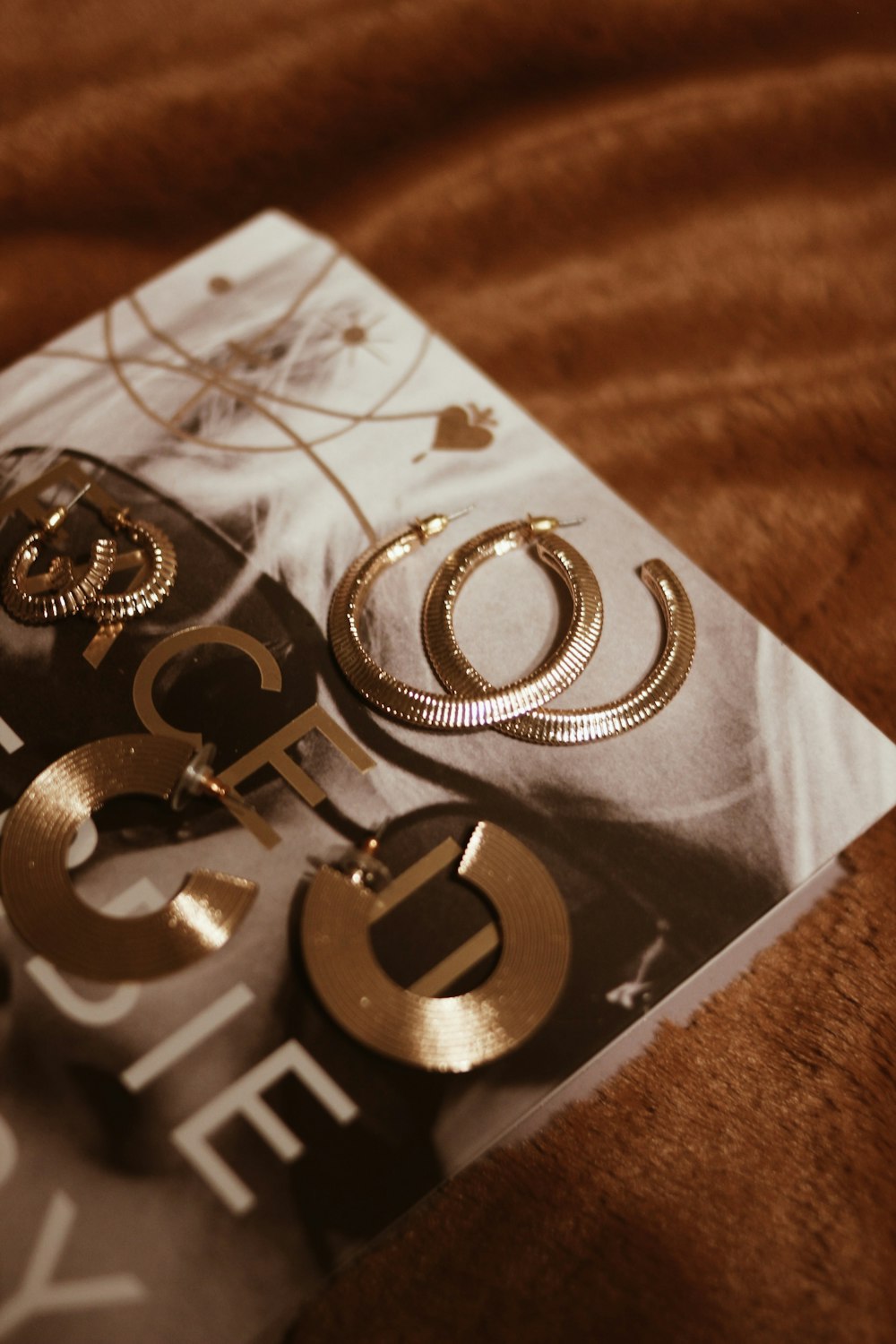 silver and gold bracelet on white paper