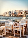 brown wooden chairs on seashore during daytime