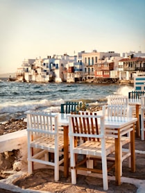 brown wooden chairs on seashore during daytime