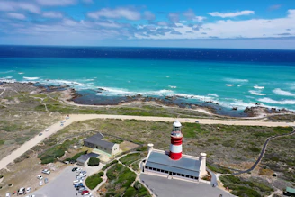 white lighthouse near body of water during daytime