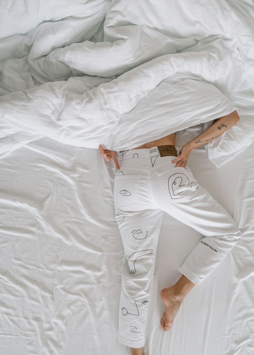 woman in white dress lying on bed