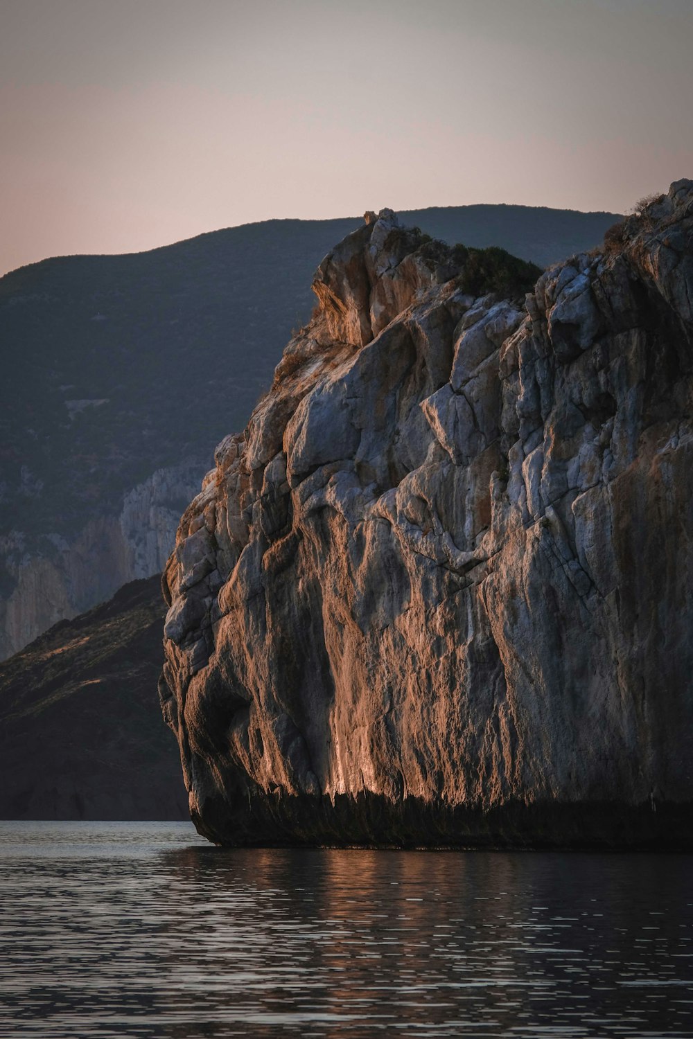 brown rock formation near body of water during daytime