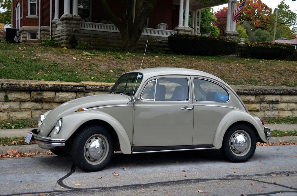 white volkswagen beetle parked on gray concrete pavement during daytime