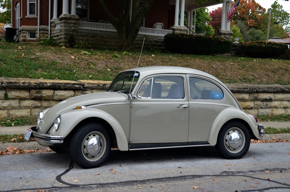 Volkswagen Beetle blanco estacionado en pavimento de concreto gris durante el día