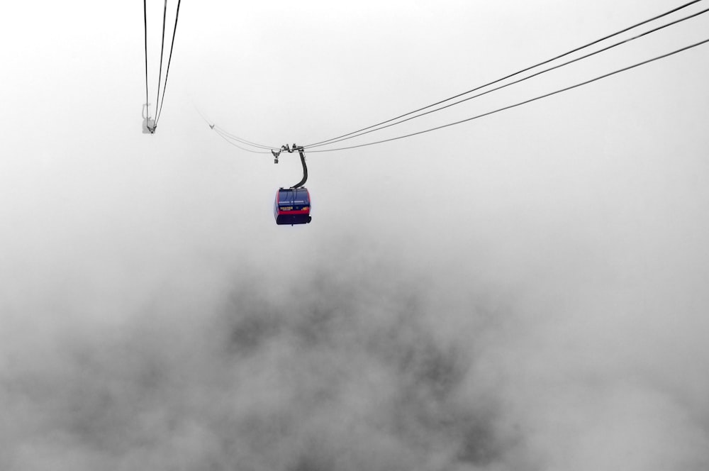 blue and white cable car under gray clouds