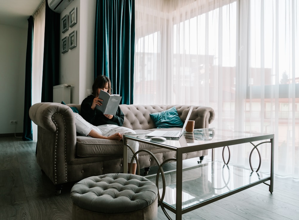 woman in white shirt sitting on gray couch