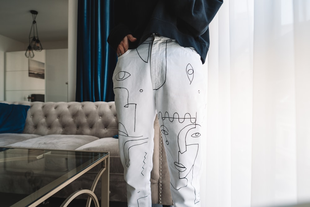 person in black and white pajama set standing near white sofa