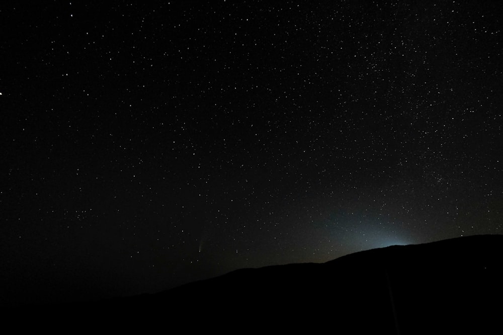 silhouette of mountain under starry night