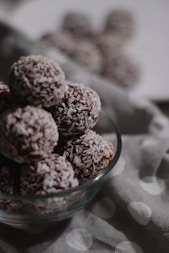 brown and white round fruits in clear glass bowl