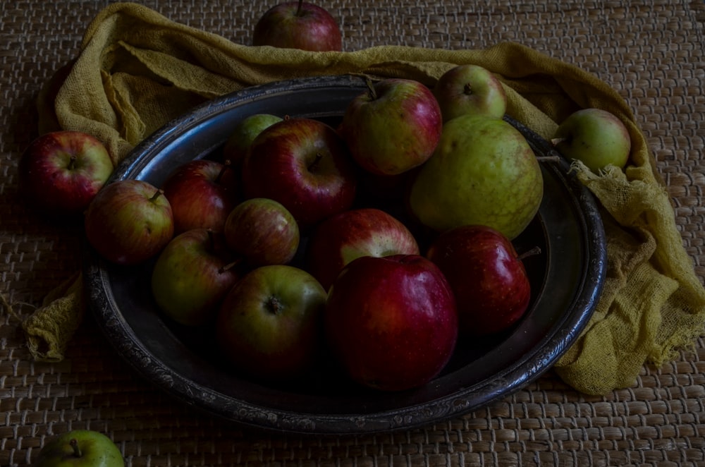 green and red apples on black round plate