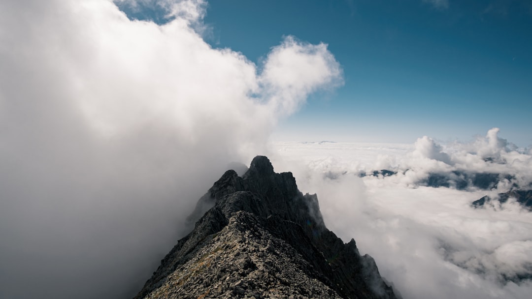 white clouds over brown mountain