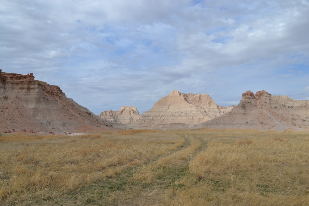 brown rock formation under white clouds during daytime