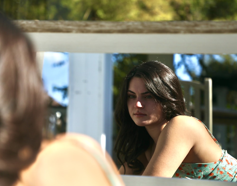 Femme en lunettes de soleil noires assise sur une chaise