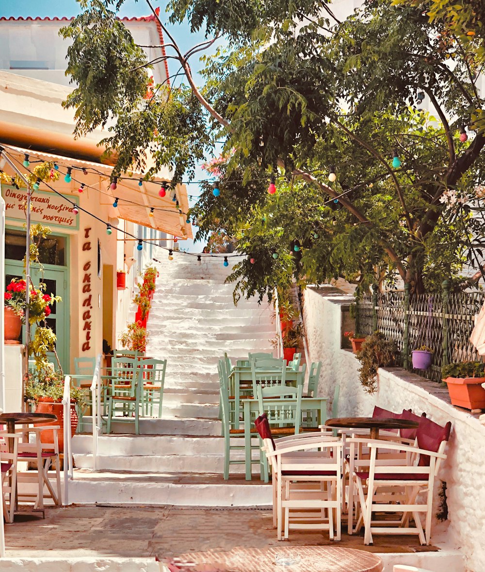 brown wooden chairs and tables near green trees during daytime