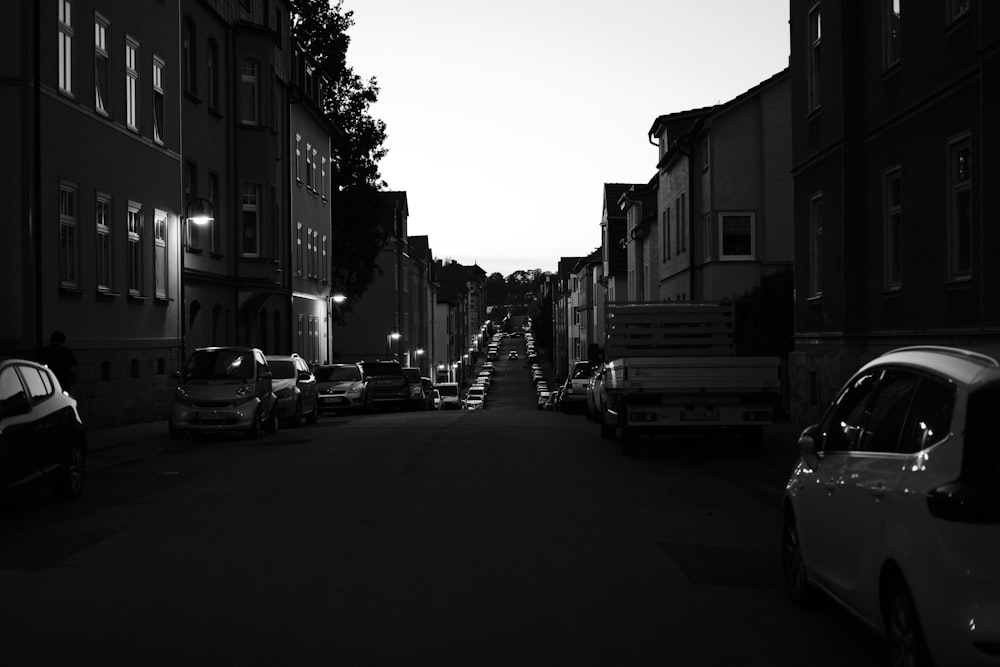 cars parked on side of the road in grayscale photography
