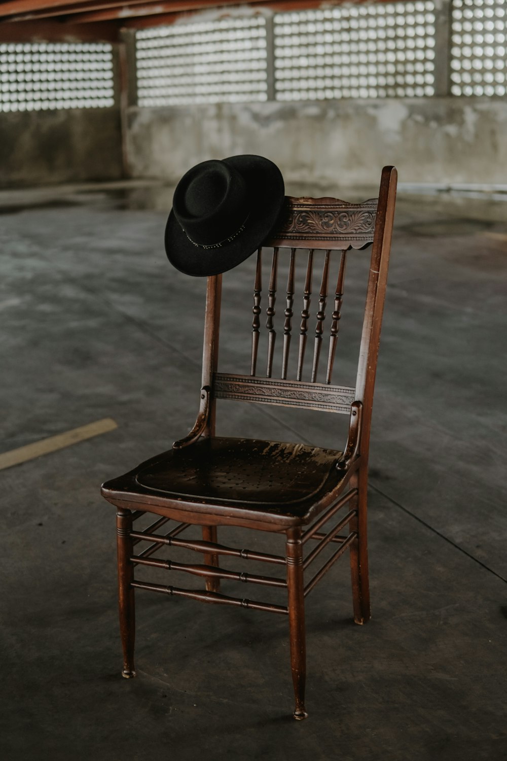 black hat on brown wooden chair