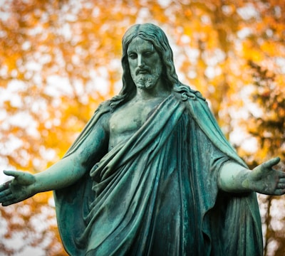 statue of a woman with a background of trees