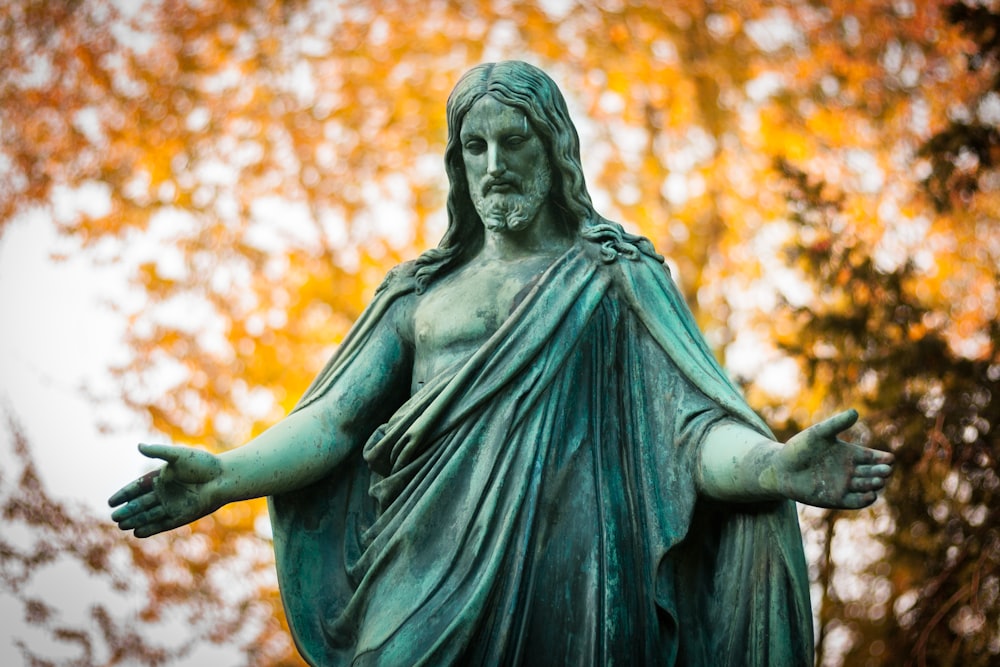 statue of a woman with a background of trees