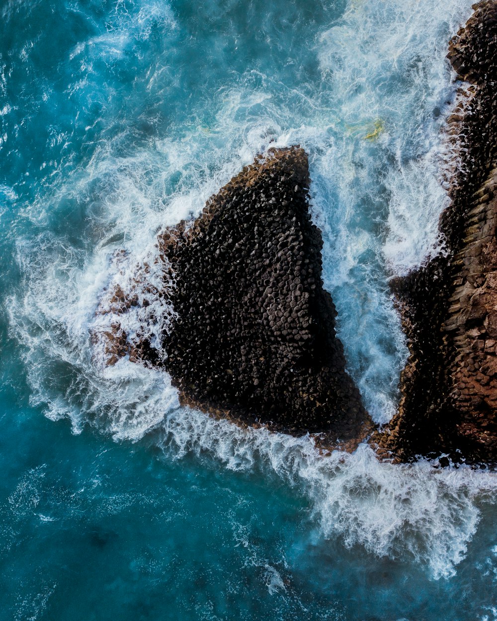 brown rock formation on body of water during daytime