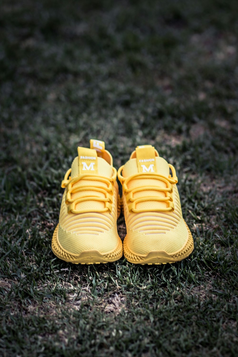 yellow nike athletic shoes on green grass