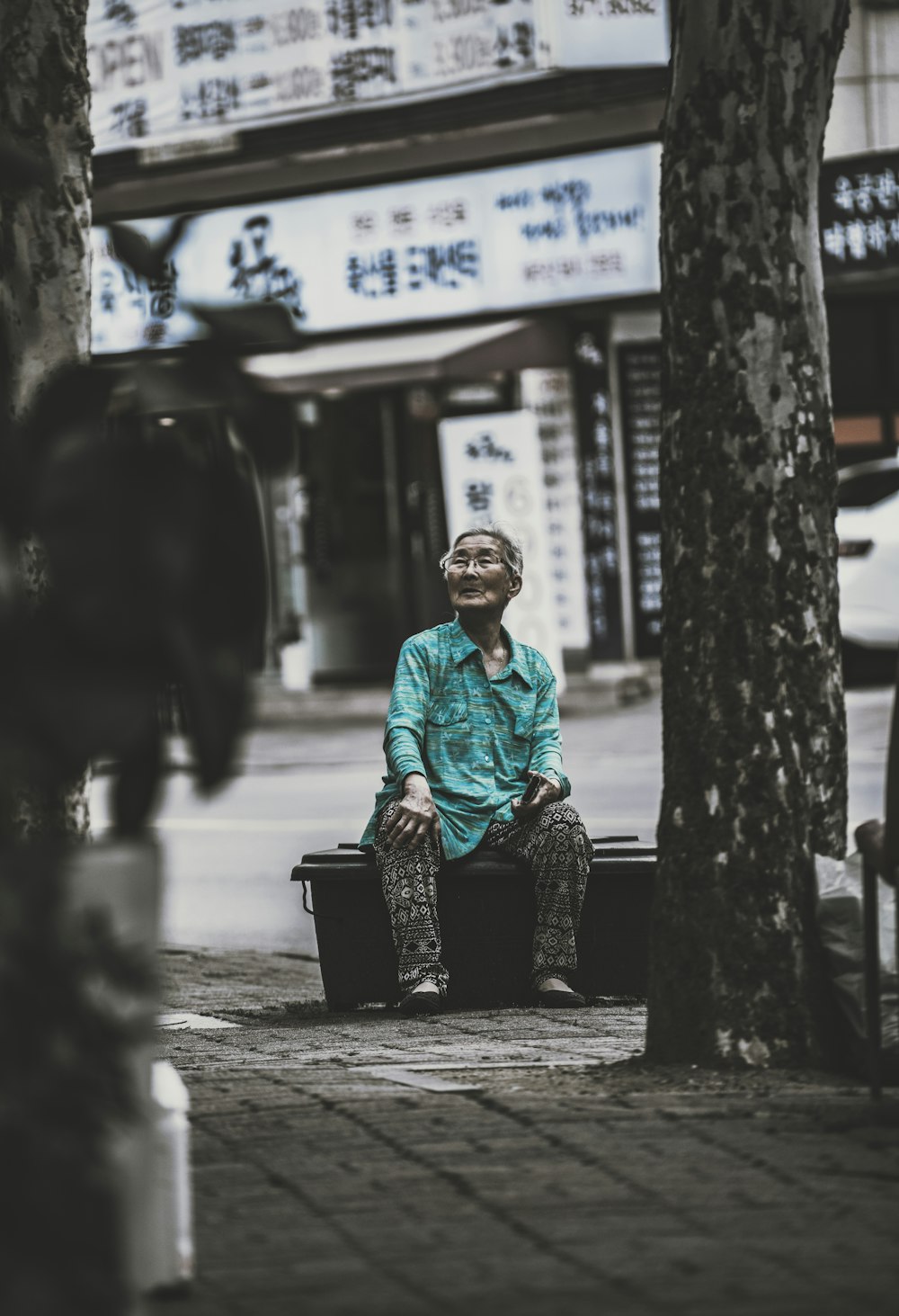 a man sitting on a bench in the middle of the street