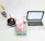 A laboratory setup with a black cylindrical apparatus attached to tubes on the left, a white digital scale displaying '293.2 g' in the center with a transparent beaker containing pink liquid on top of it, a digital thermometer, and a silver-colored laptop with an open screen on the right.