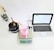 A laboratory setup with a black cylindrical apparatus attached to tubes on the left, a white digital scale displaying '293.2 g' in the center with a transparent beaker containing pink liquid on top of it, a digital thermometer, and a silver-colored laptop with an open screen on the right.