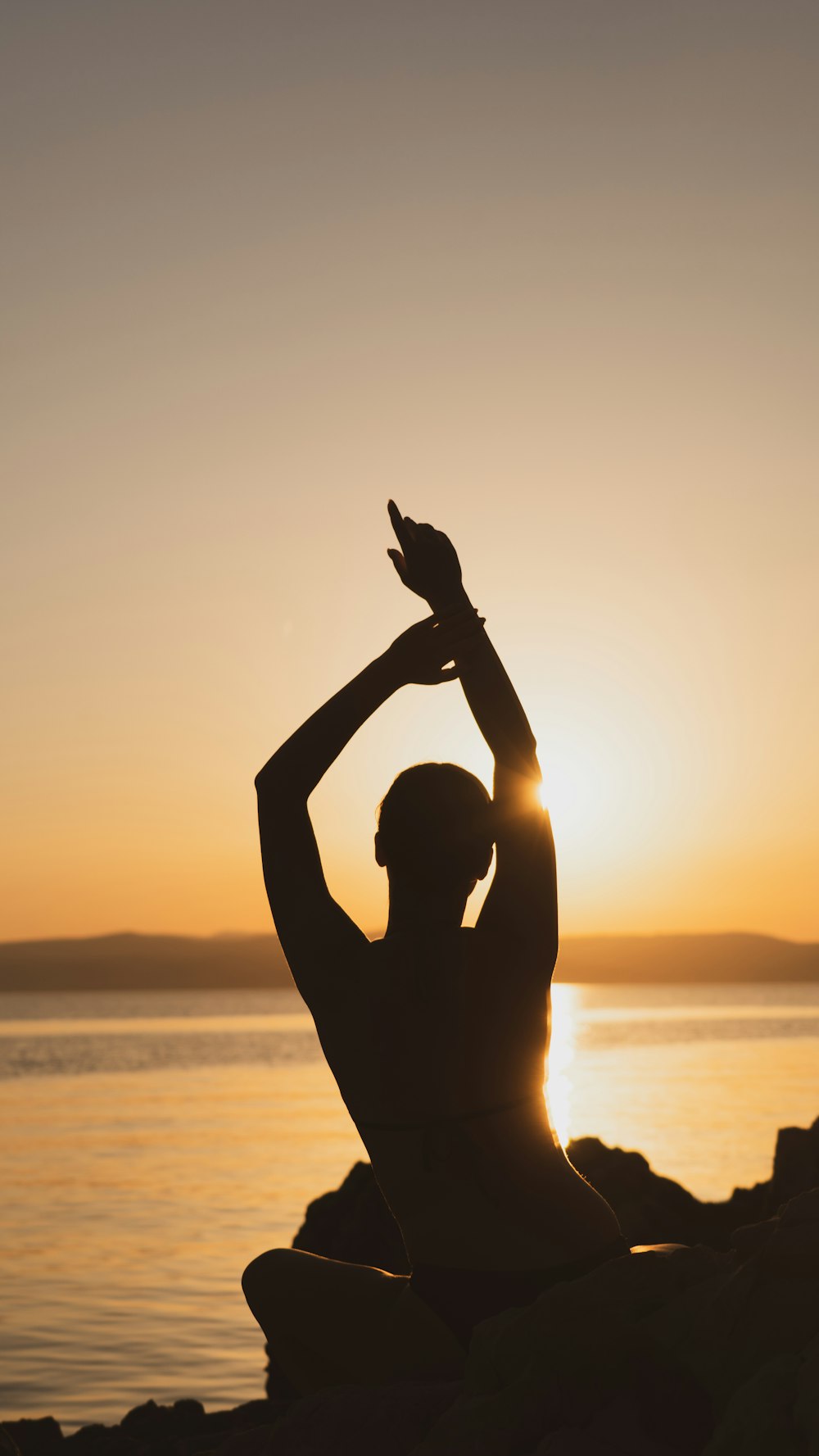 silhouette of man raising his hands during sunset