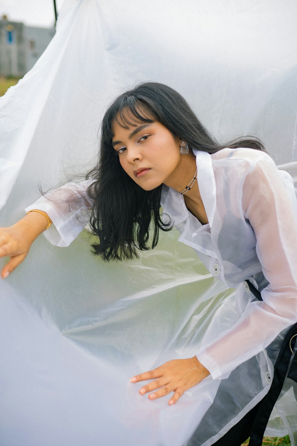 woman in white dress shirt and white pants sitting on white textile