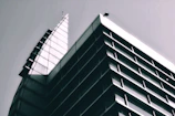 Front view of a sleek modern building with sharp angles in monochrome tones.