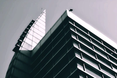 Front view of a sleek modern building with sharp angles in monochrome tones.