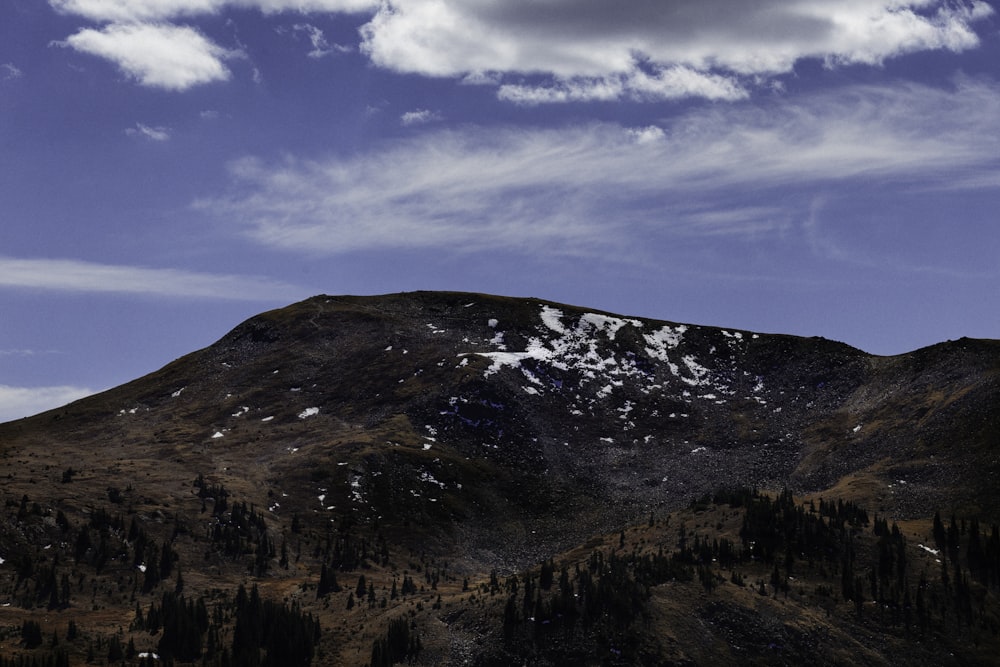 Brauner und grüner Berg tagsüber unter blauem Himmel