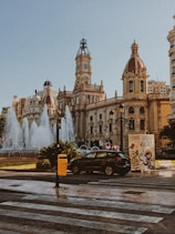 black car parked near white concrete building during daytime