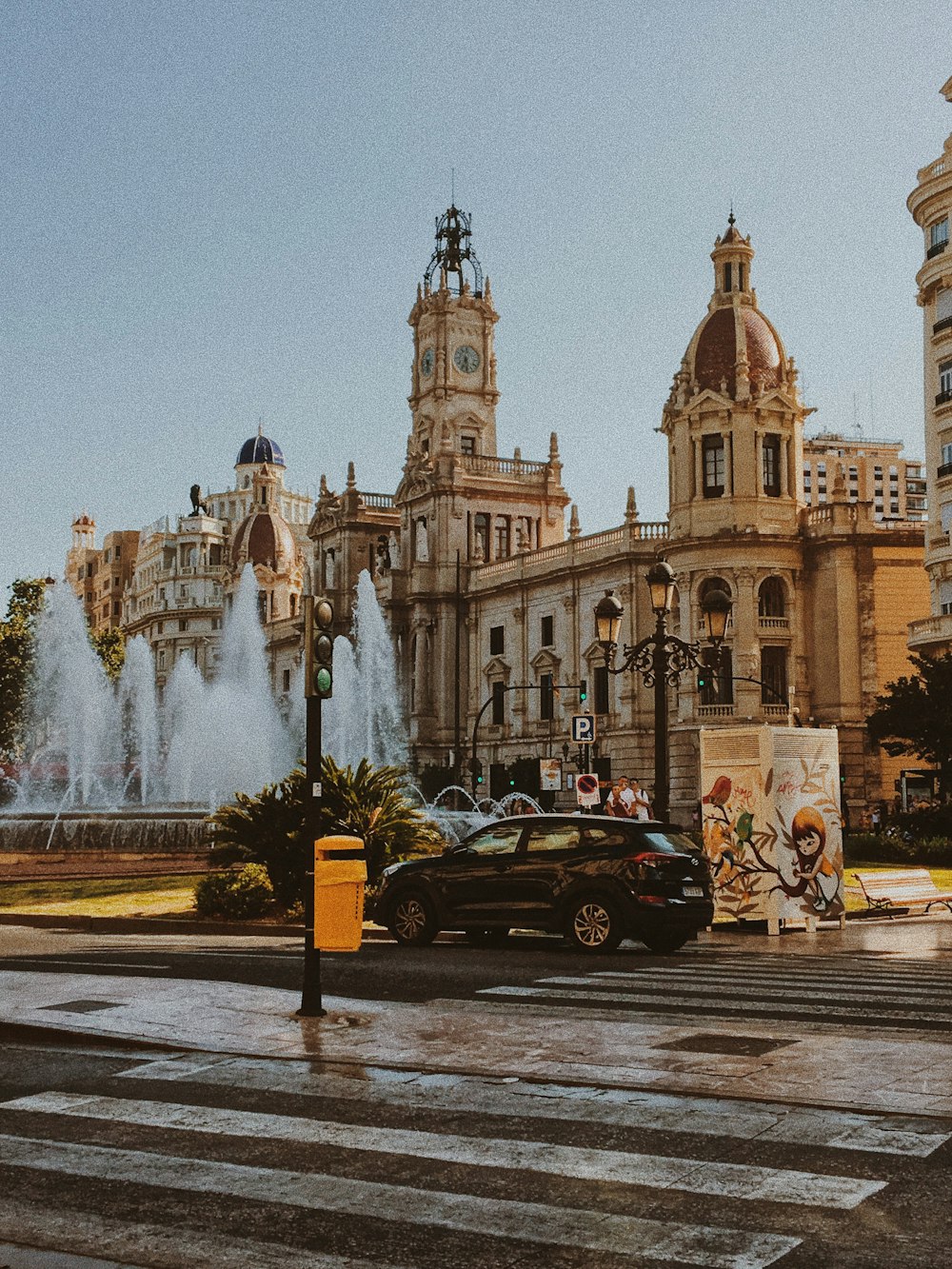 carro preto estacionado perto de edifício de concreto branco durante o dia