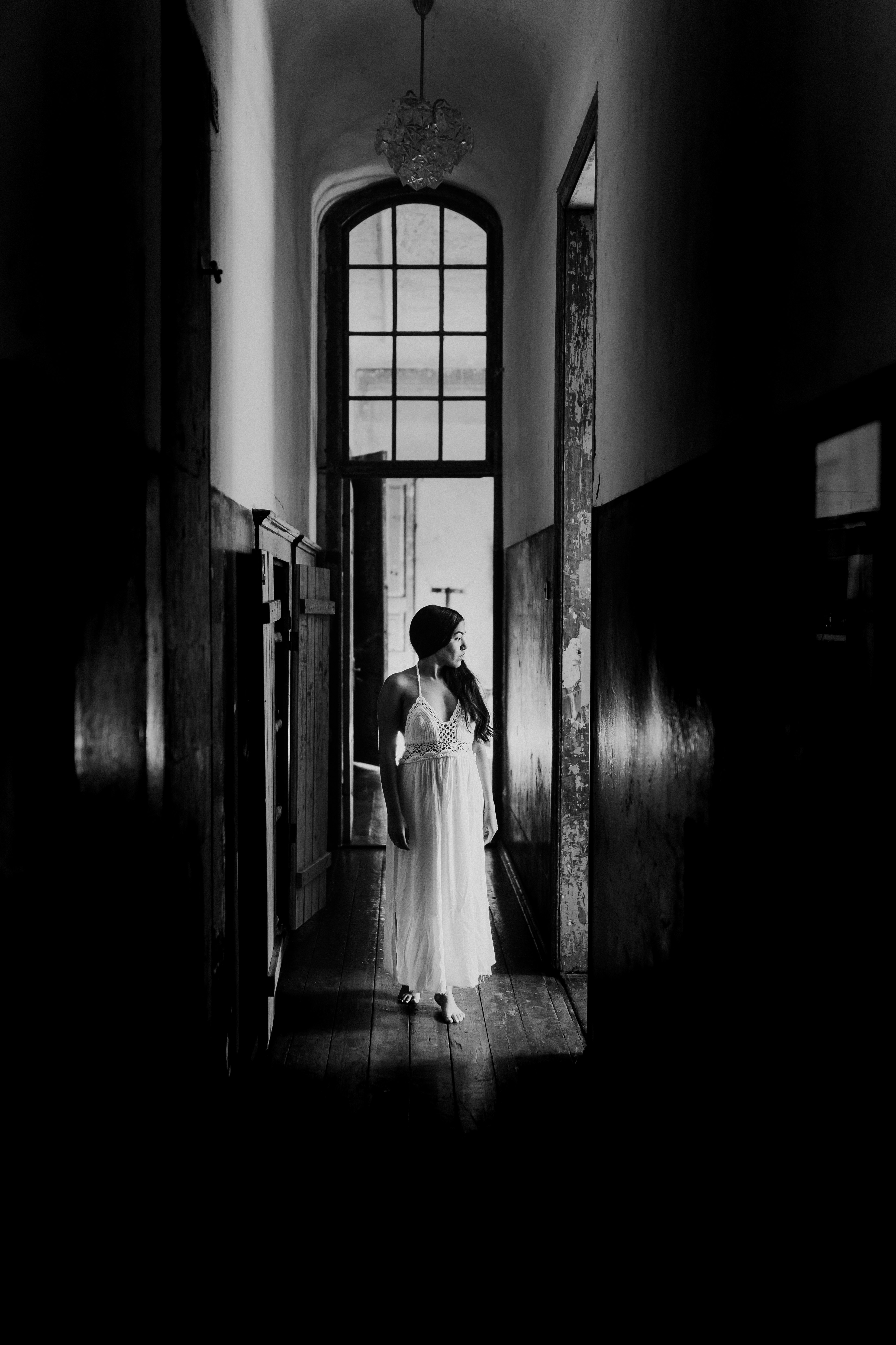 woman in white dress walking on hallway
