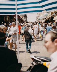 A lively street scene with people enjoying a sunny day in a colorful market.