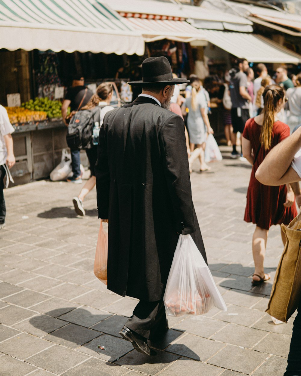 man in black academic dress walking on street during daytime