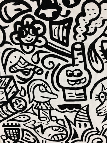 A black and white abstract pattern features cartoon-like characters and playful shapes. Among these are a smiling flower, a fish, a whimsical face with a hat, and a box with facial features. Curved lines and swirls interweave to create a dynamic composition.