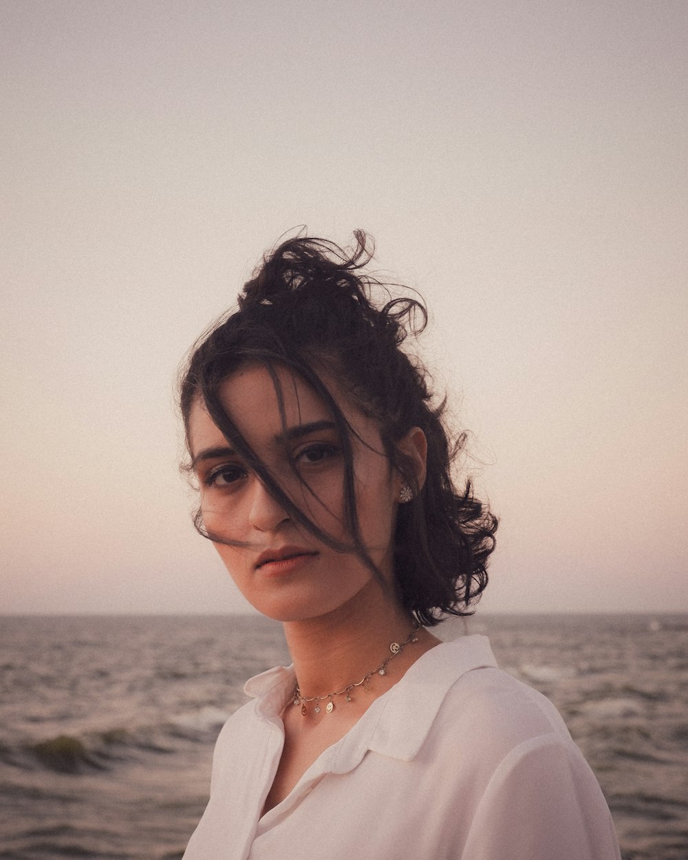 woman in white shirt standing near sea during daytime