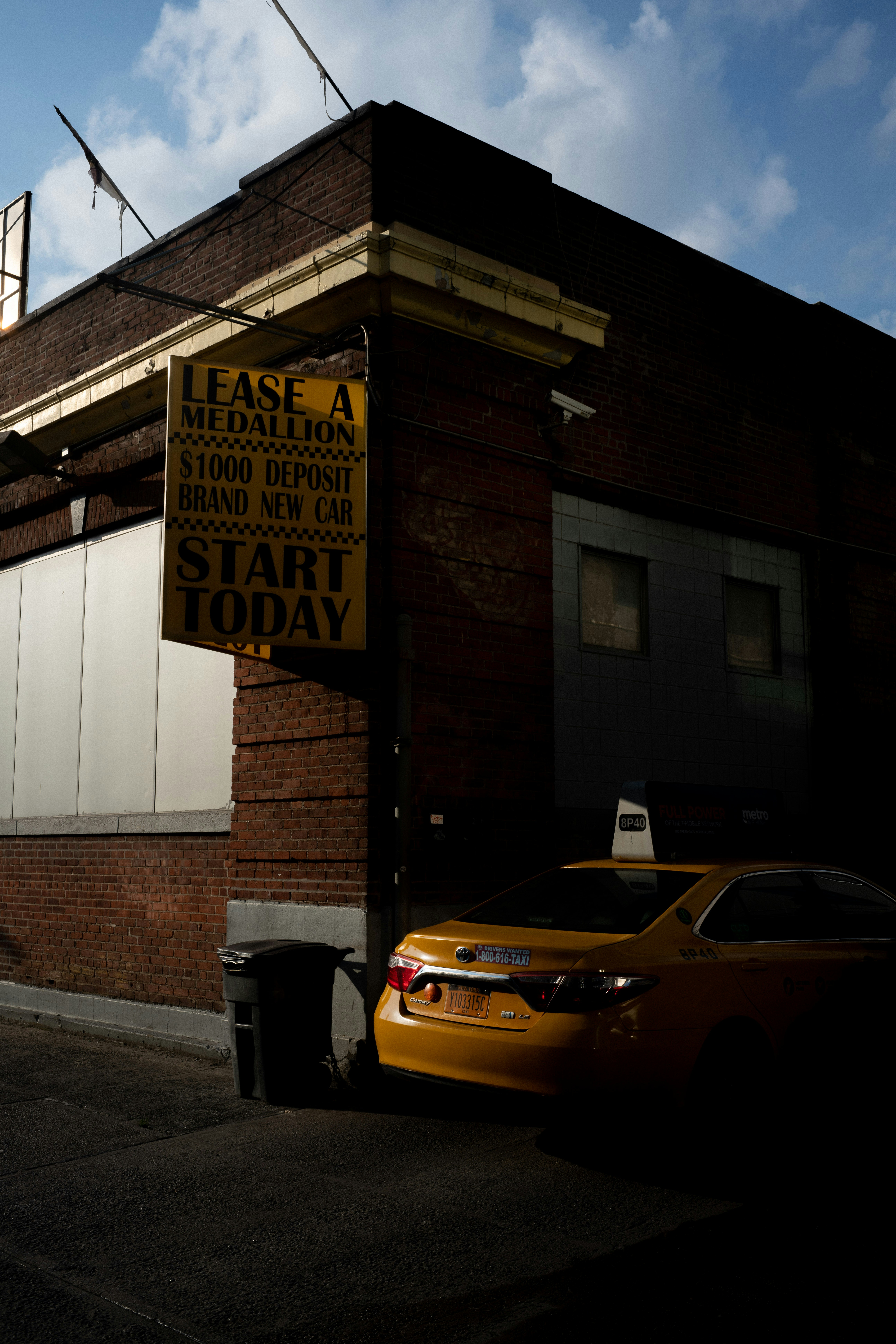yellow car parked beside brown brick building