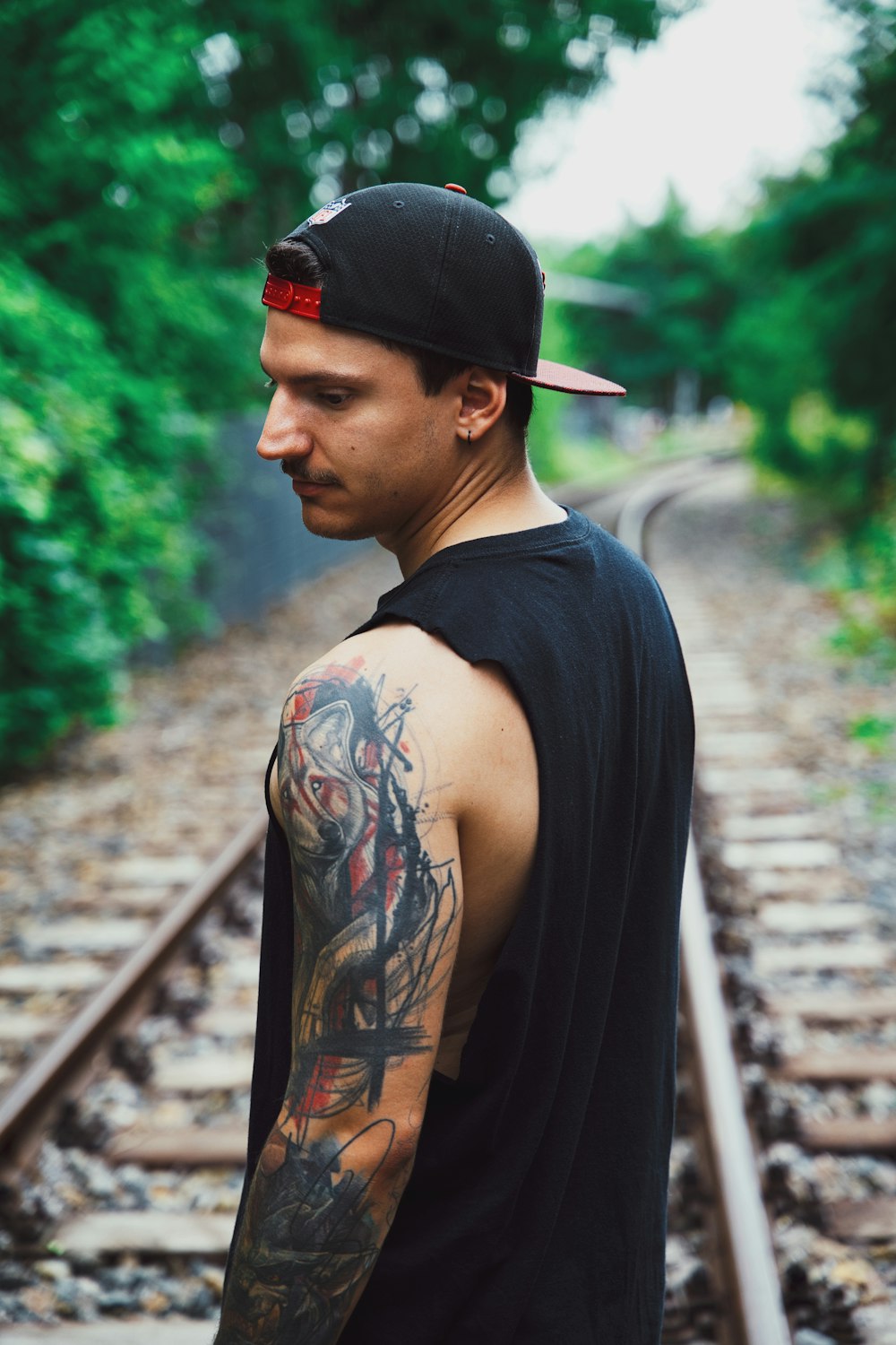 man in black tank top with black tattoo on his back