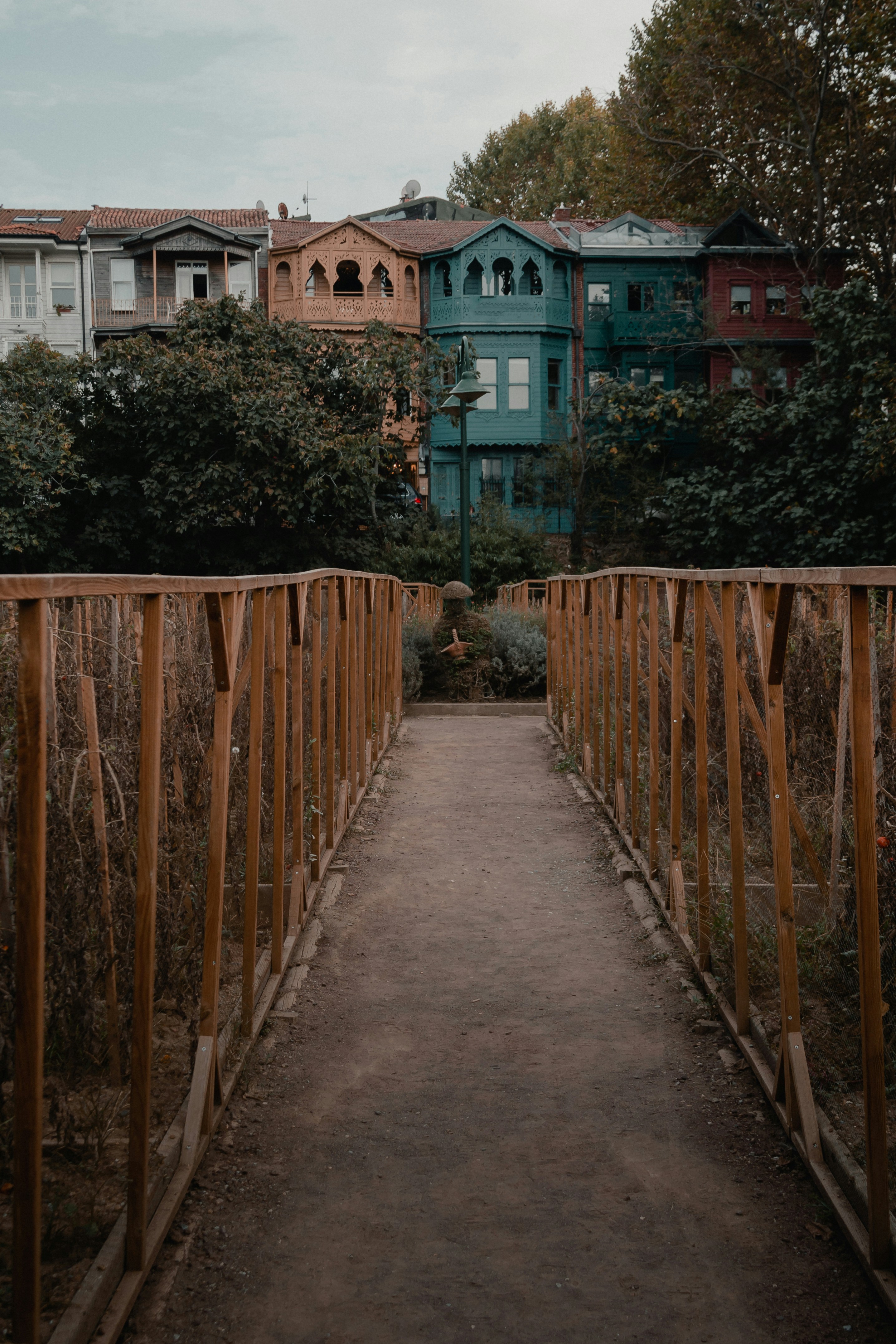 brown wooden fence near green trees and brown wooden fence