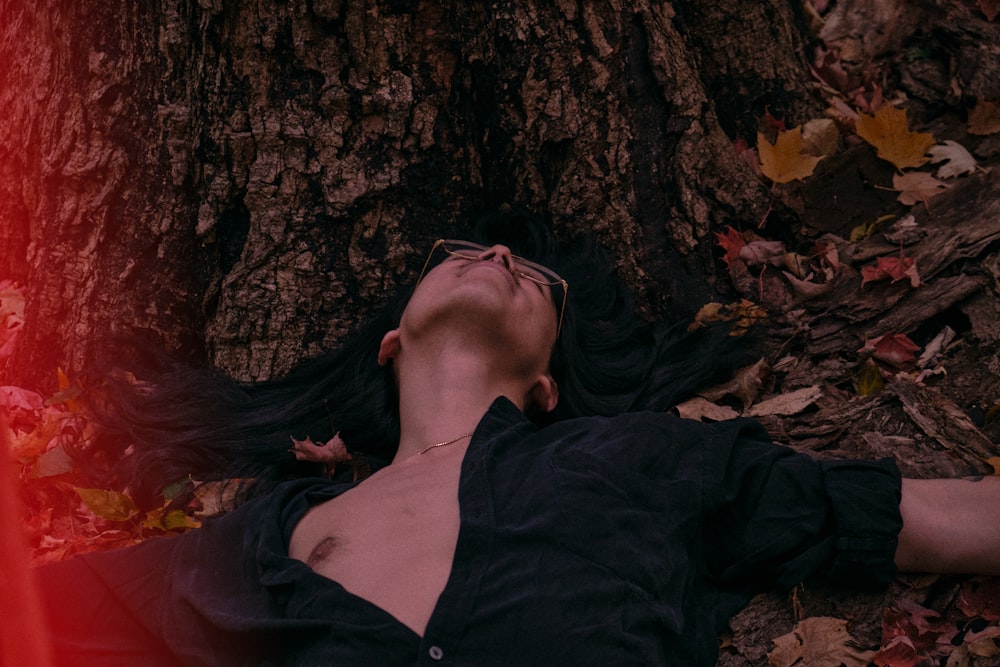 woman in black jacket lying on brown rock