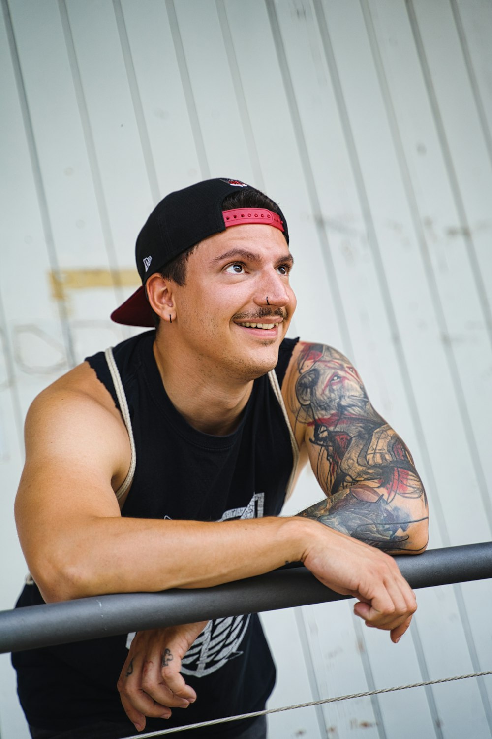 man in black tank top and red fitted cap