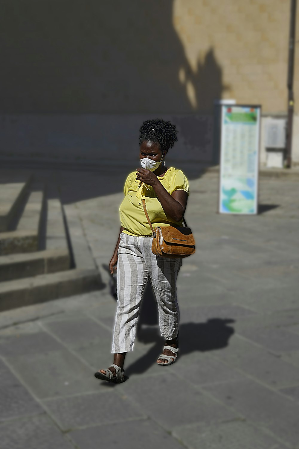 Hombre con polo amarillo y pantalones blancos de pie sobre piso de concreto gris durante el día