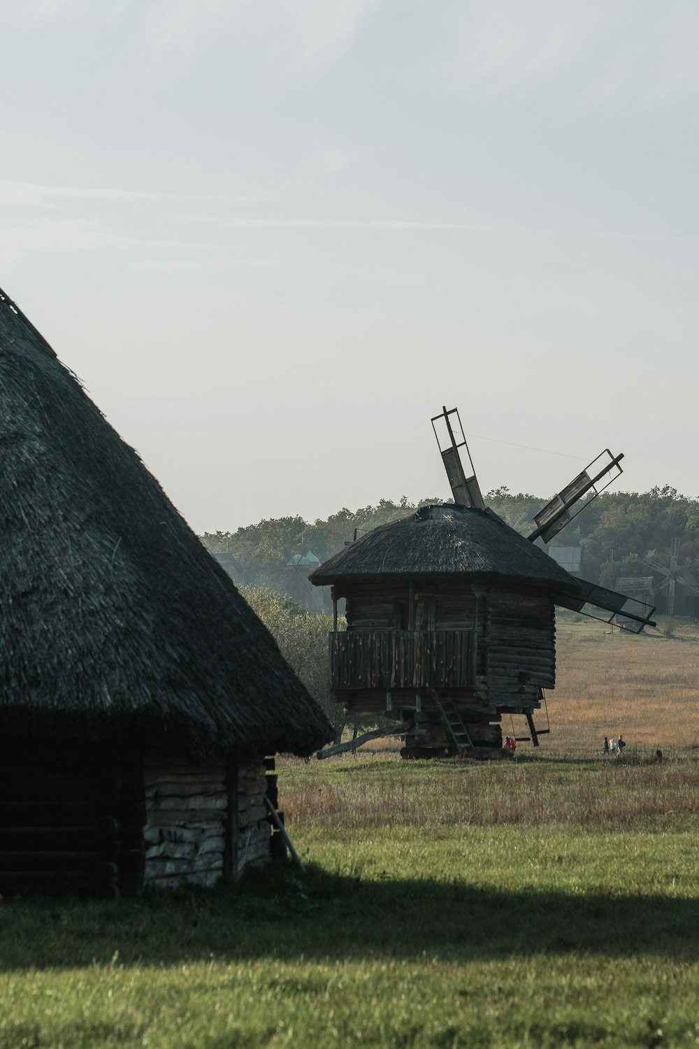 brown wooden house near green grass field during daytime