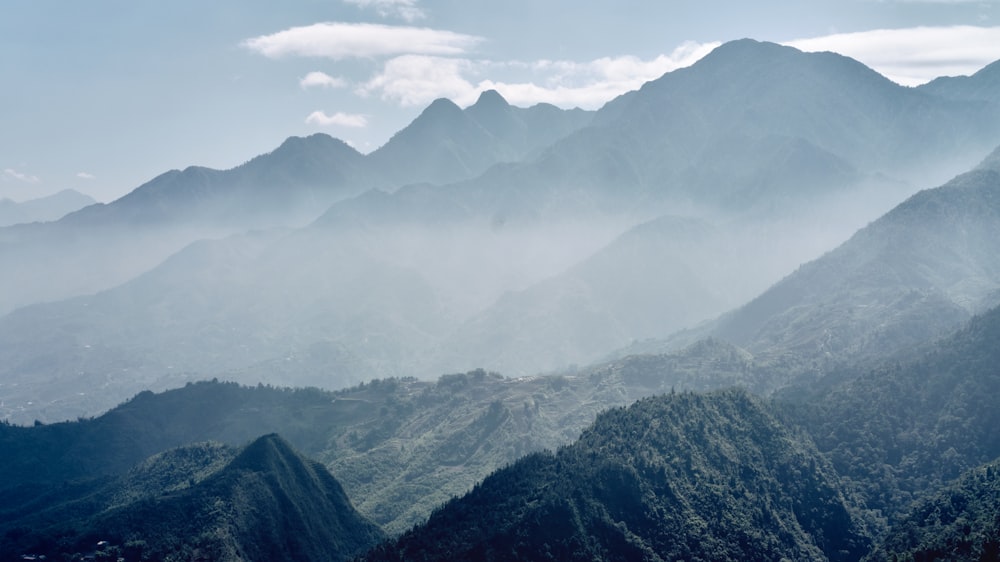 Grüne und schwarze Berge unter weißen Wolken tagsüber