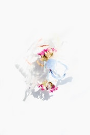 A beautifully decorated masquerade mask resting on a navy blue and champagne silk fabric backdrop.