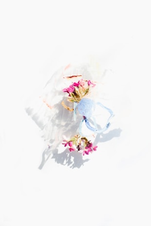 A beautifully decorated masquerade mask resting on a navy blue and champagne silk fabric backdrop.