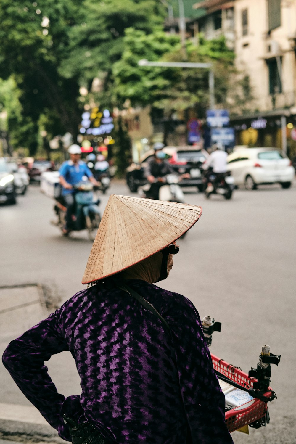 woman in black and white long sleeve shirt wearing brown straw hat standing on street during